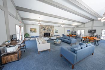 A spacious living room with a fireplace and a variety of seating options